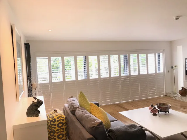 Made-to-measure white wooden shutters fitted to a large window in a detached Glasgow home